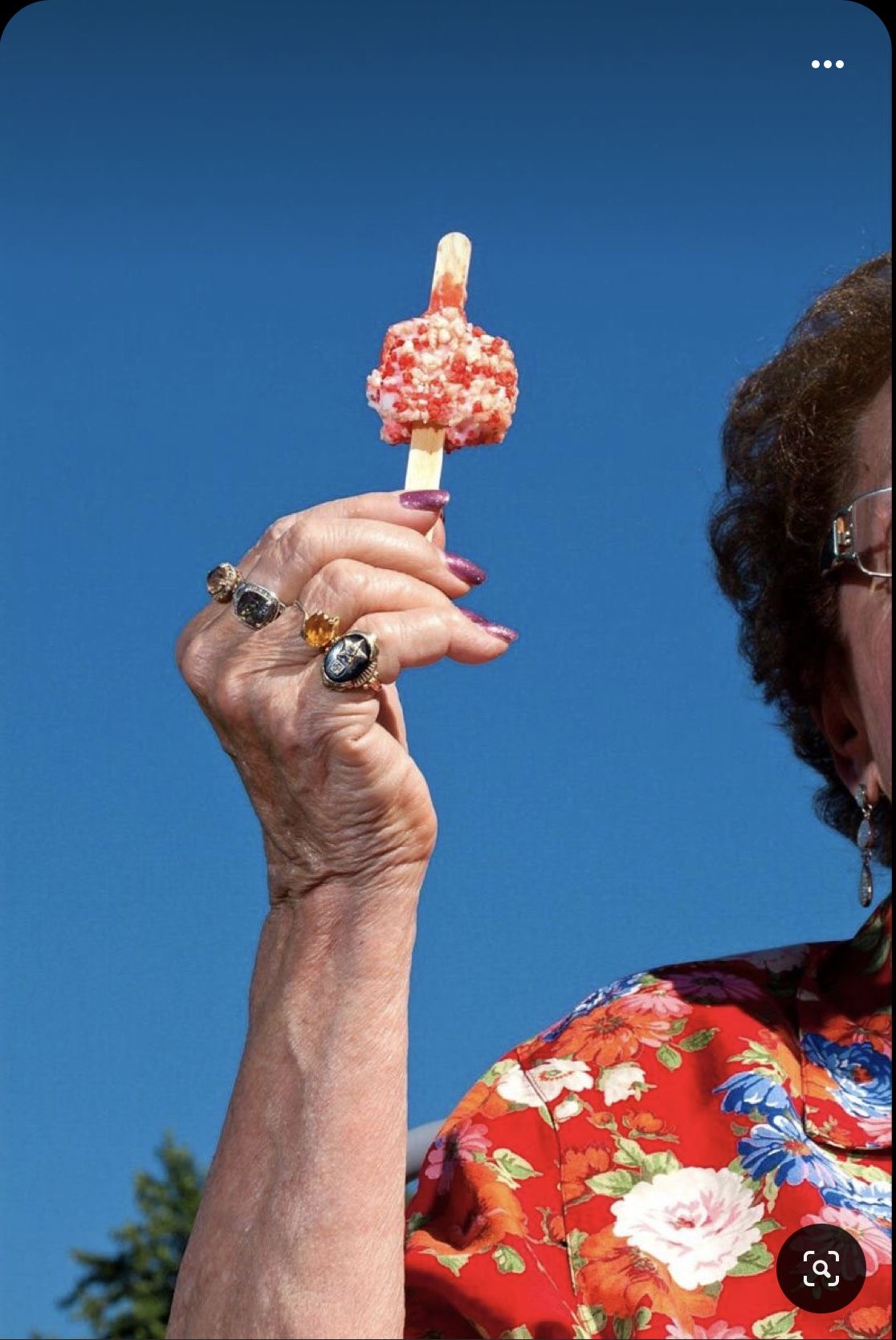 Guest holding a strawberry shortcake novelty ice cream bar at an outdoor event